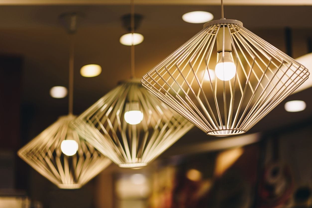 Three pendant lights with bent wire fittings hanging from a ceiling